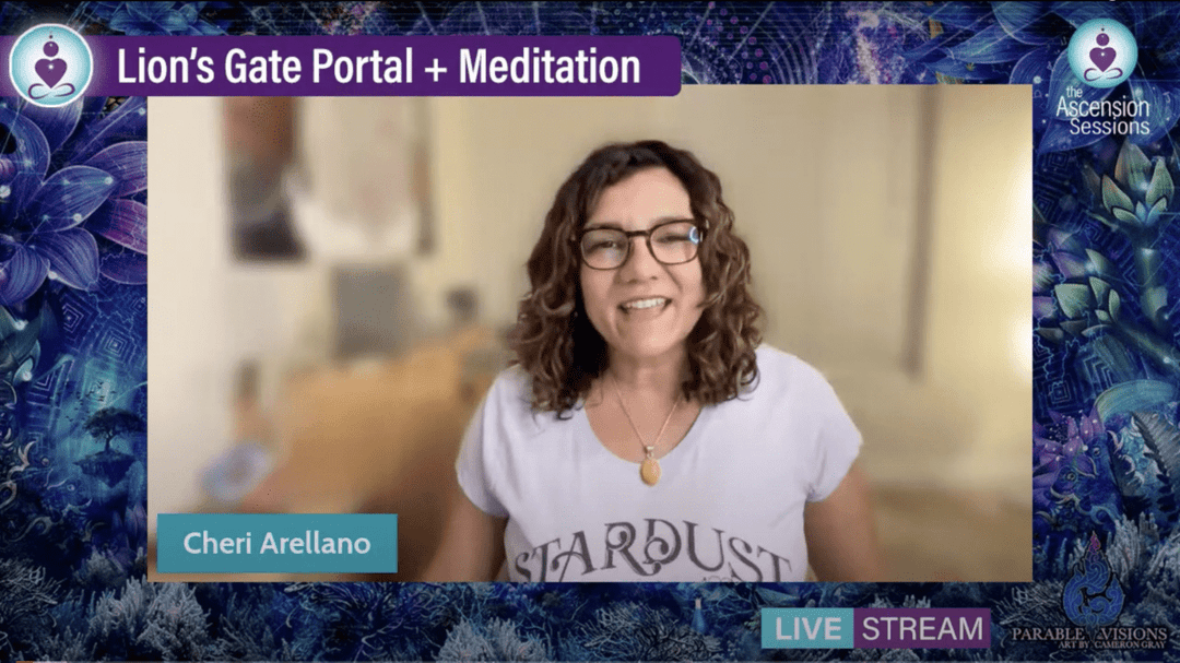 Woman with curly hair and glasses smiling during Lion's Gate Portal meditation livestream