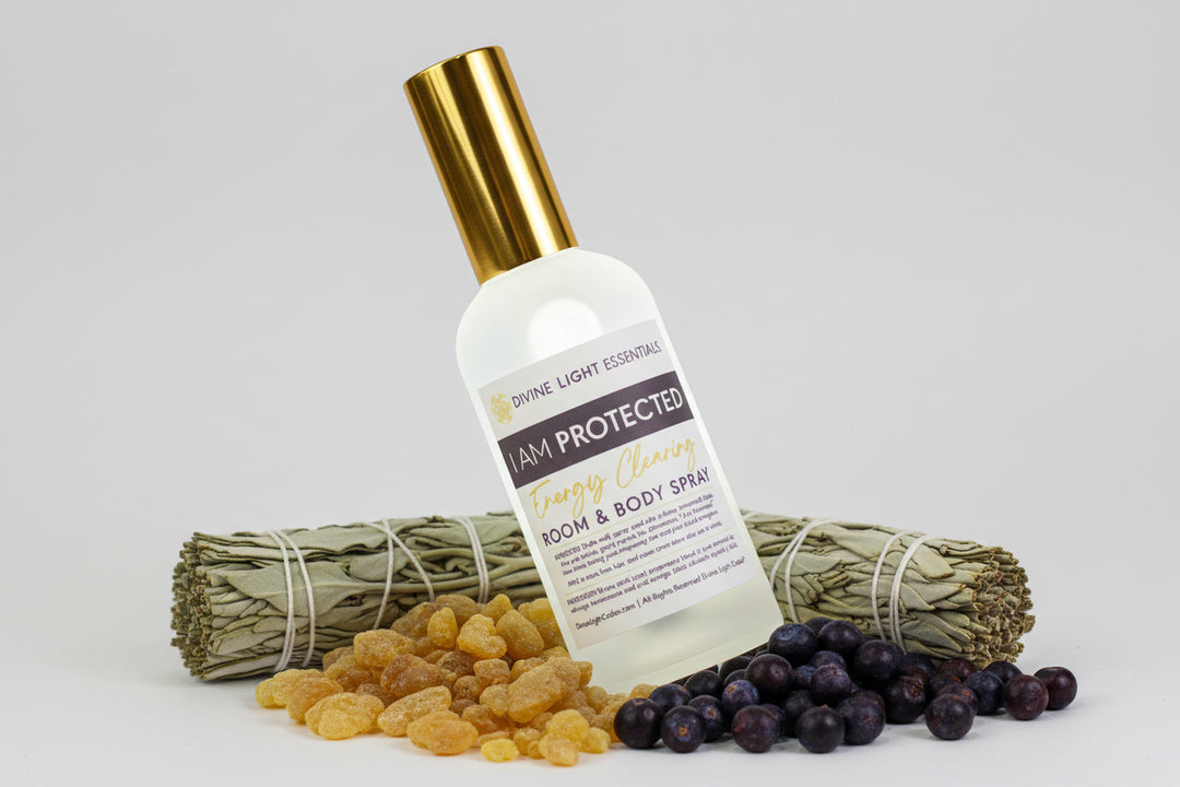 Bottle of 'I Am Protected' room and body spray with gold cap on pink background