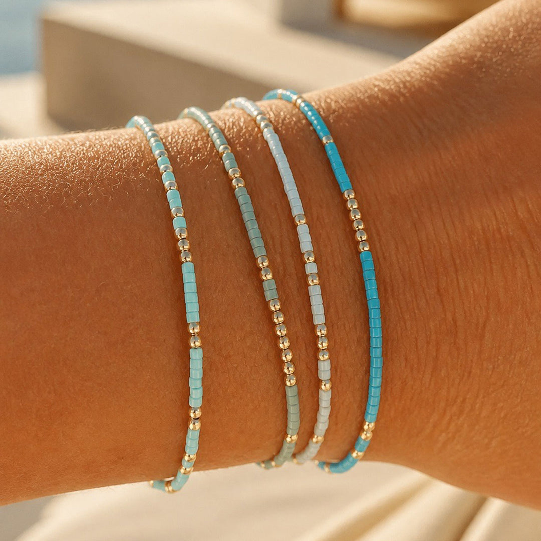 Four beaded stretch bracelets on a person&