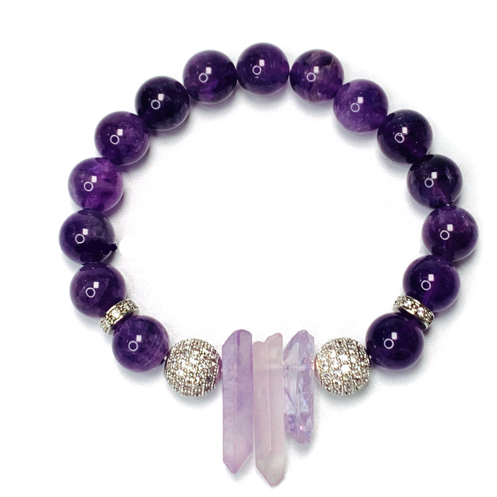 A purple beaded bracelet with clear quartz and amethyst crystals, featuring a mix of 8 and 10 mm beads, and a rhinestone embellishment.