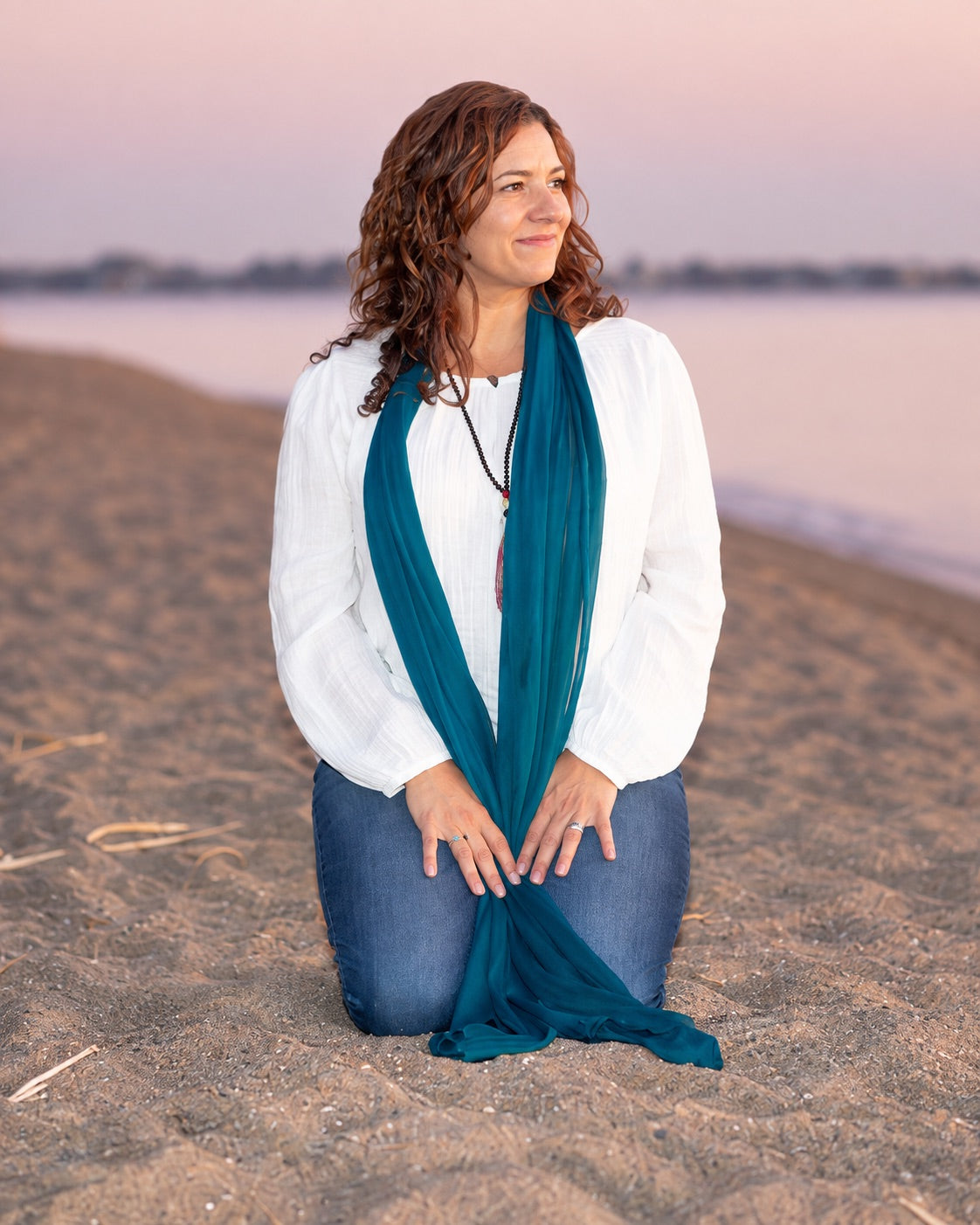 Cheri Arellano kneeling on the beach at sunset, cropped for the mobile Blog Page banner
