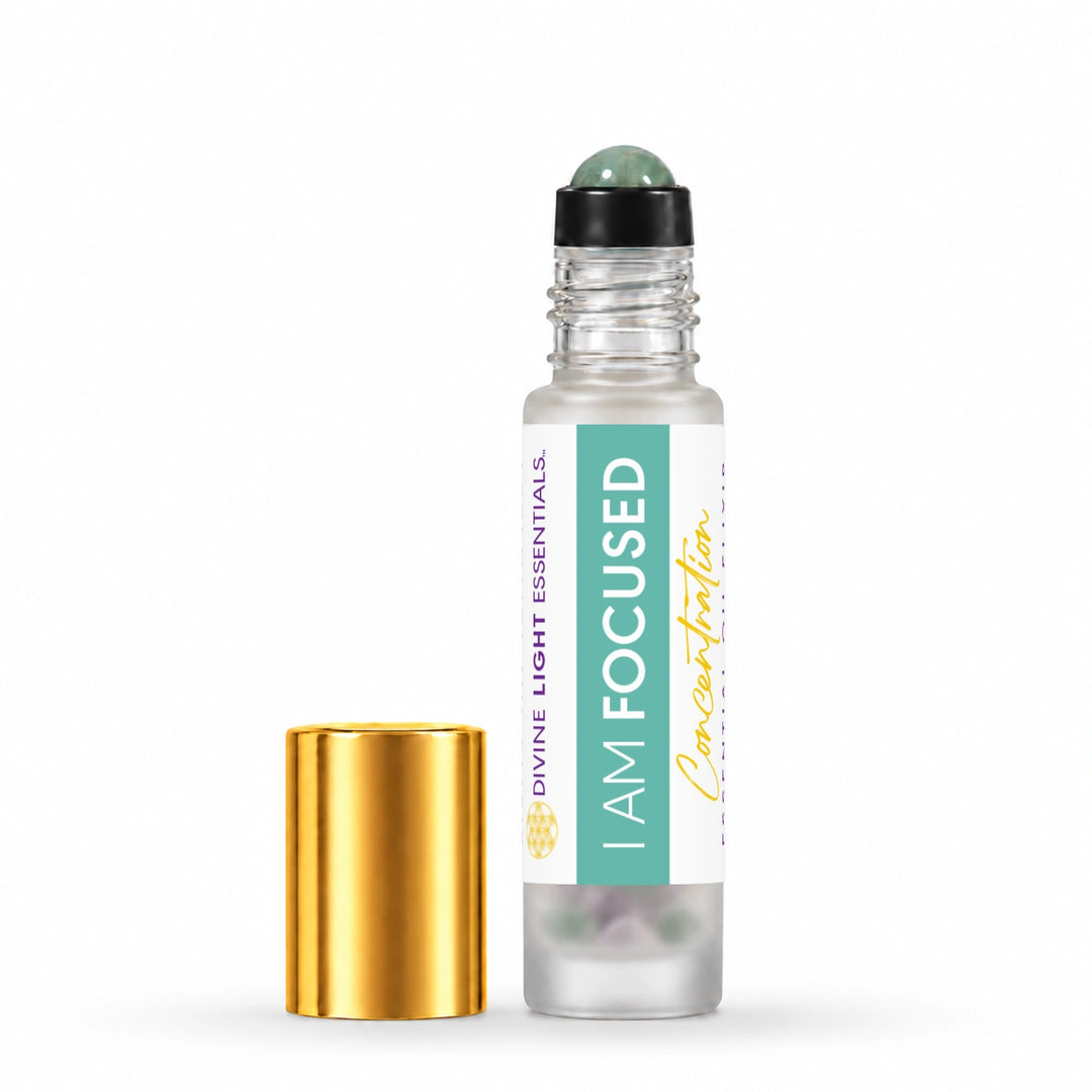 A clear glass roller bottle labeled I AM FOCUSED by Divine Light Essentials, shown with its detached shiny gold cap on a clean white background.