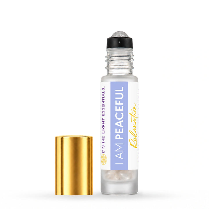 I Am Peaceful roller bottle with its crystal rollerball exposed and gold cap beside it on white.