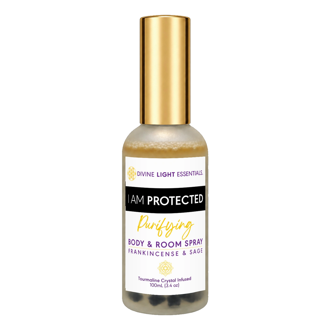 A 100ml bottle of Divine Light Essentials 'I Am Protected Purifying Body & Room Spray' featuring a white label with gold and black text, a gold cap, and visible dark crystals at the bottom, set against a plain white background.