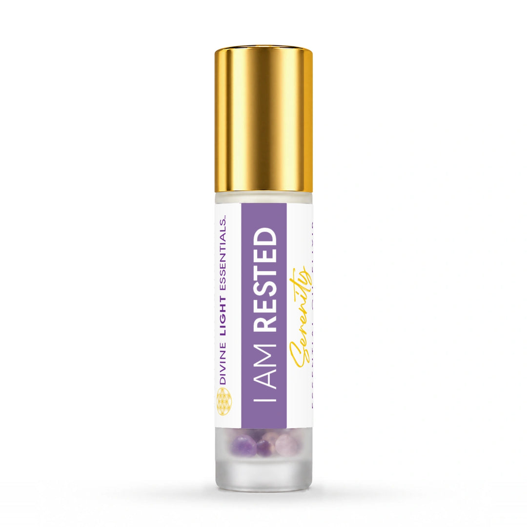 Gold-capped I Am Rested essential oil roller bottle on white.