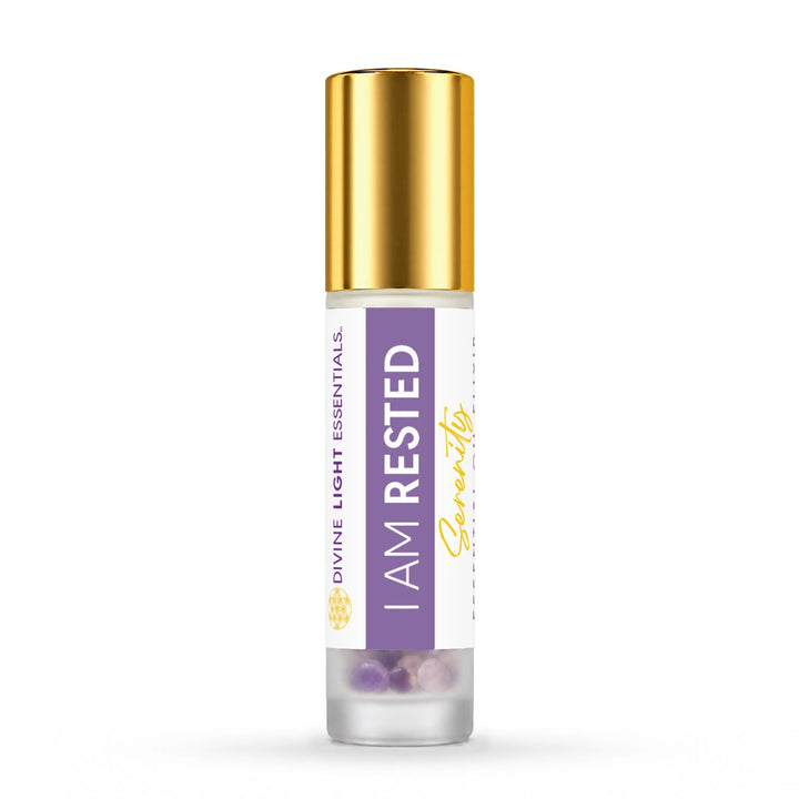 Gold-capped I Am Rested essential oil roller bottle on white.
