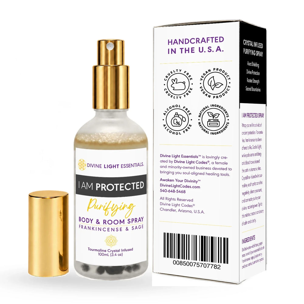 Divine Light Essentials 'I Am Protected' Purifying Body and Room Spray, featuring a clear glass bottle with a gold spray nozzle and a separate gold cap, shown next to its white cardboard packaging box on a white background.