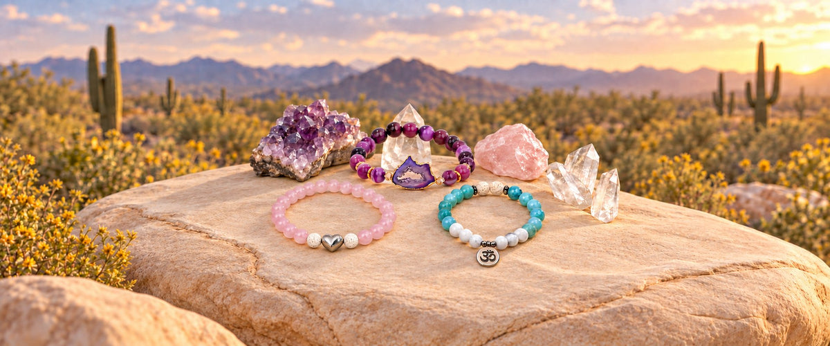 Pink, turquoise and purple beaded bracelets arranged with quartz crystals on a desert rock.