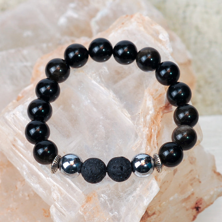 Black beaded bracelet with silver accents on a crystal background