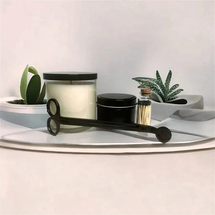 Decorative items including a candle, jars, and plants on a white surface with a light gray background.