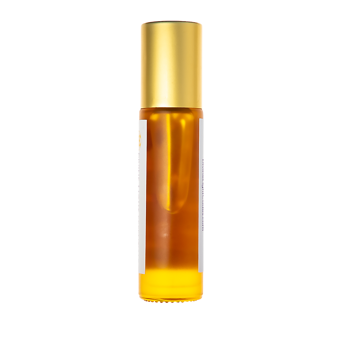 A cylindrical amber glass roller bottle with a shiny gold cap and a white label, shown against a solid white background.