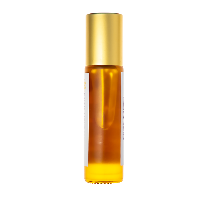 A cylindrical amber glass roller bottle with a shiny gold cap and a white label, shown against a solid white background.