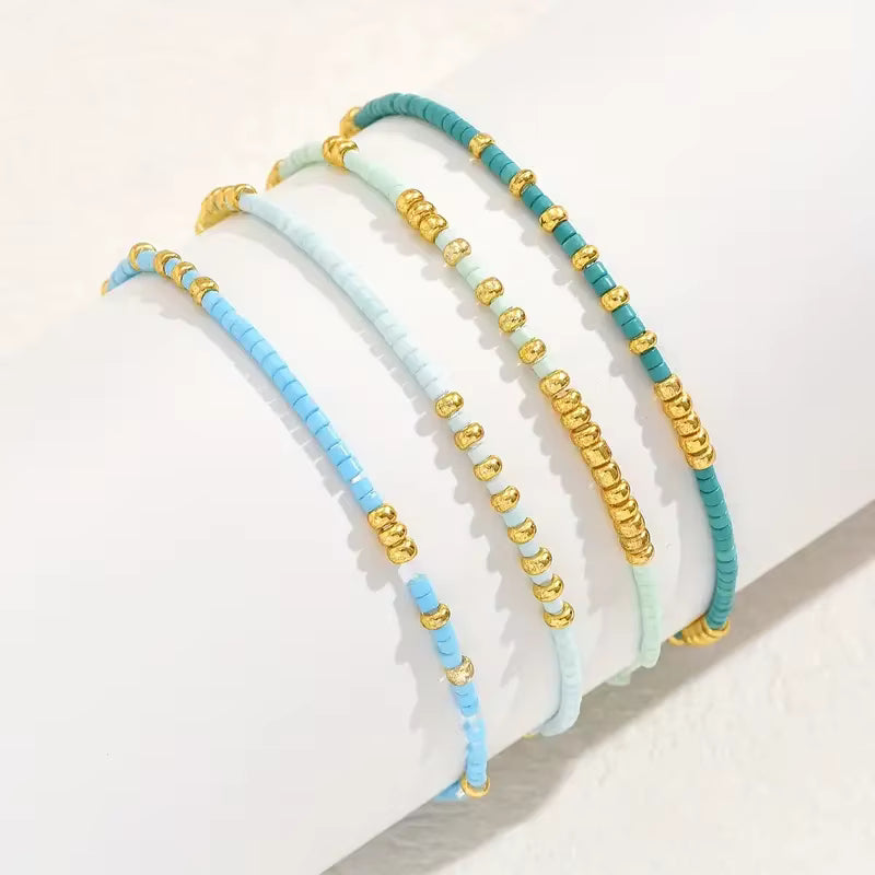 Set of beaded headbands with gold and turquoise colors on a light background